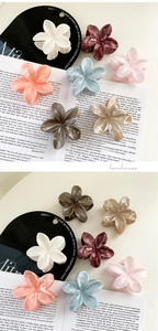 Detailed close-up of marble textured flower hair claws in multiple pastel cream colors