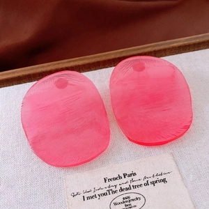 Detailed macro view of pink resin geometric earrings with a brushed matte texture finish