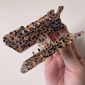 Close-up of large acetate leopard print hair claw clip showing glossy texture and spring