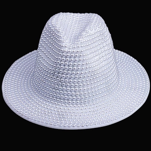 Detailed view of white bucket hat with luxury pearl embellishments on black background