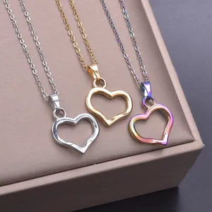 Macro detail of heart pendants in silver, gold, and rainbow finish on a jewelry mat