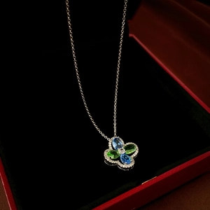 Close-up of luxury flower necklace with blue and green crystals in a black velvet jewelry box