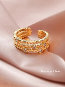 Macro shot of gold-plated triple-row zircon ring on pink satin with 1.7cm diameter