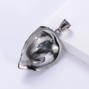 Macro shot of silver stainless steel shell pendant with black texture and polished bail