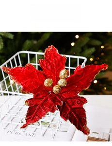 Vue macro d'une fleur de Noël rouge avec bords pailletés dorés et baies au centre
