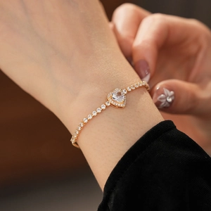Detailed view of heart-shaped zircon bracelet with halo setting on a female wrist