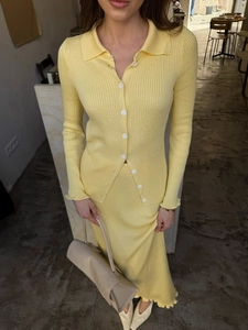 Vue détaillée de la texture en maille côtelée jaune chaud sur l'ensemble gilet et jupe