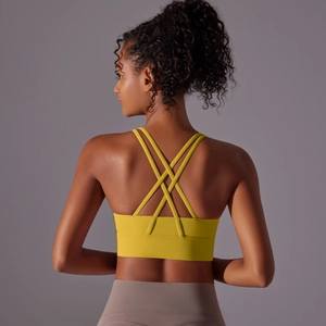 Dettaglio spalline incrociate del reggiseno sportivo giallo con fascia larga