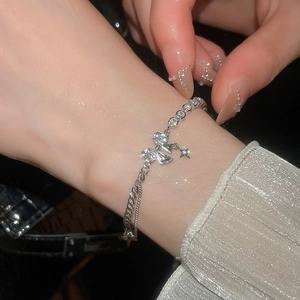 Macro shot of a butterfly charm bracelet with zircons and stars on a model wrist