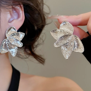 Detailed macro view of silver abstract flower earrings with textured metallic petals