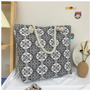Detail of printed canvas tote bag with black and white geometric patterns and rope handles