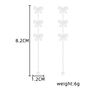 Detail view of bow tassel earrings with dimensions 8.2cm length and 6.g weight
