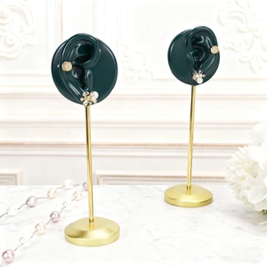 Floral pearl earrings with rhinestones on a green display stand with marble base