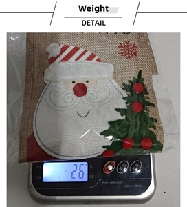 Detailed close-up showing a 26g Christmas burlap wine bag on a digital weight scale