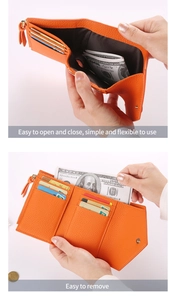 Macro detail of an orange litchi grain leather wallet with multiple card slots and zips