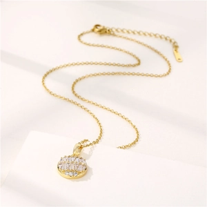 Gold stainless steel round pendant necklace with micro-paved zircons on a white stand