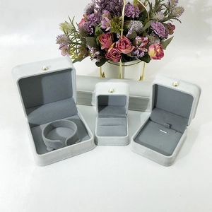 Detailed view of light gray velvet jewelry boxes with elegant pearl clasp buttons
