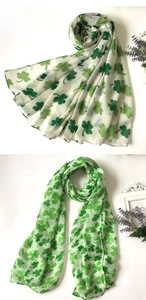 Detailed pattern of green shamrock prints on a cream white lightweight voile scarf