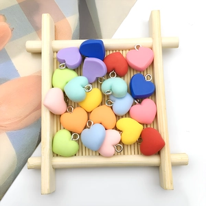 Colorful resin heart pendants for DIY jewelry making displayed on a bamboo tray