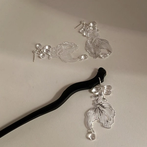 Detailed view of silver filigree koi fish earrings and matching hair stick set