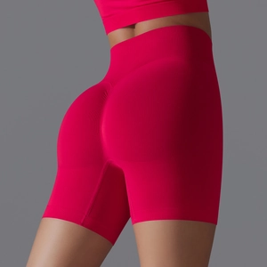 Detail view of red seamless high-waist yoga shorts with lifting seam and ribbed texture