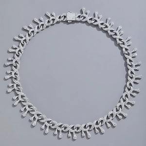 Détail d'une chaîne hip hop argentée avec pendentifs en goutte et fermoir en diamant