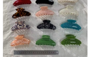 Detailed overhead view of large 9cm colorful hair claws in various glossy finishes