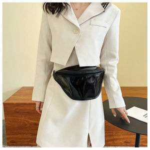 Fashionable black patent leather waist bag styled with a beige suit for a chic urban look