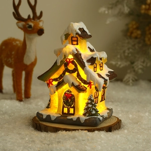 Detailed close-up of a glowing Christmas resin house village with warm LED lights inside