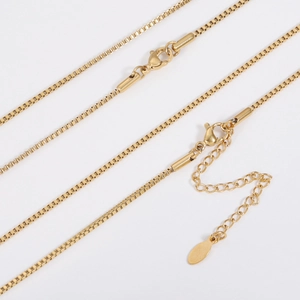 Close-up of golden box chain necklace with lobster clasp and adjustable extension link