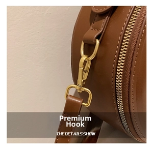 Detailansicht der braunen runden Tasche mit hochwertigen goldenen Metallbeschlägen