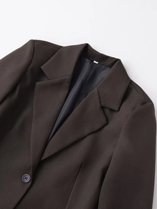 Detail of dark brown blazer featuring a classic notch lapel and resin button closure