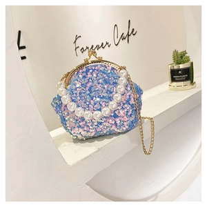 Detail of blue sequin shell bag with large pearl handle and gold chain strap