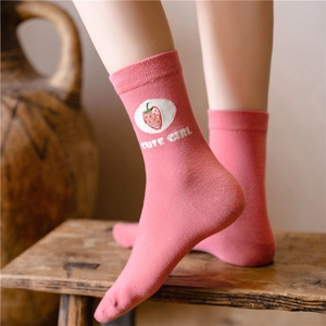 Detail of pink cotton sock featuring cute girl text and strawberry embroidery