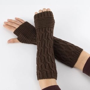 Detail of dark brown cable-knit fingerless gloves showing thick soft wool texture