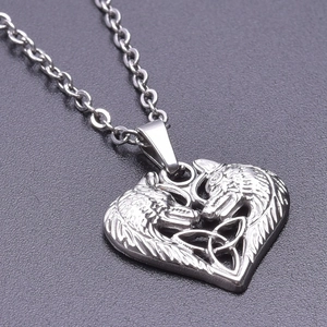 Macro view of vintage silver heart-shaped wolf pendant with detailed Celtic knot