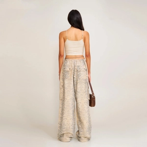 Rear view of model wearing beige cropped camisole and snakeskin print wide leg trousers