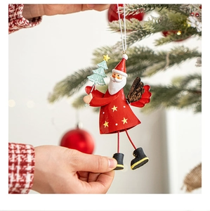 Hand holding a 3D metal Santa Claus ornament with a small tree for Christmas tree decor