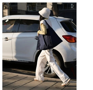 Street style shot of a large navy blue tote bag showing the stylish oversized shoulder fit