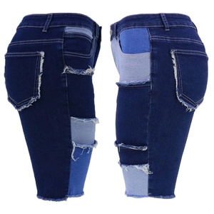 Women's patchwork denim shorts in dark blue with frayed edges and distressed details