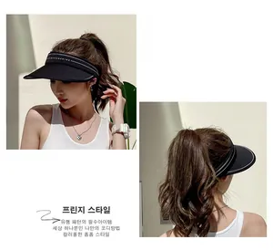 Detail of black wide brim sun hat with white contrast piping and HIOY SUNSHINE text