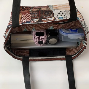 Spacious interior of canvas tote bag with laptop, umbrella, and books in multi-pocket design