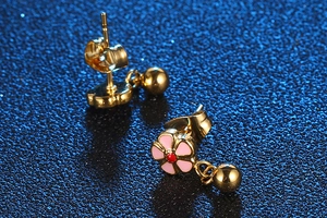 Macro detail of pink flower earrings with golden bead drop and titanium steel posts