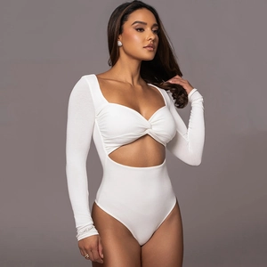Détail du body blanc à manches longues avec nœud frontal et découpe à la taille