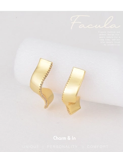 Detailed view of wave-shaped gold-plated earrings with pave-set cubic zirconia crystals