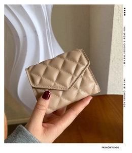 Detailed close-up of khaki quilted leather texture on a compact card holder wallet