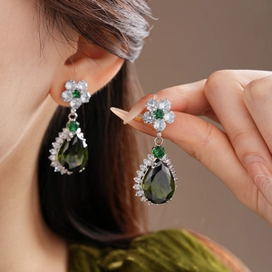 Detail of leaf flower earrings with green zircons and water drop gemstones for women