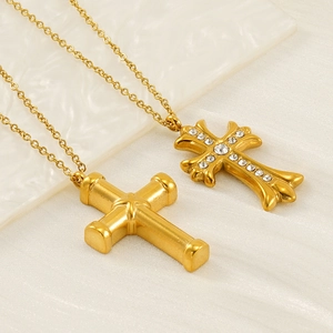 Polished gold stainless steel cross necklace with crystal pavé pendant on textured fabric