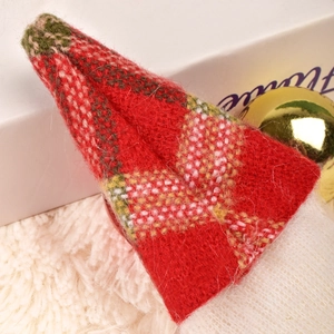 Detail of red and green plaid festive mini hat featuring textured wool knit material
