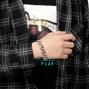 Silver Cuban link bracelet for men with diamond-encrusted details shown on wrist